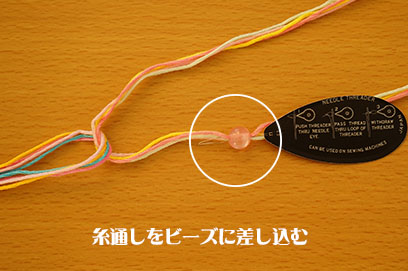 糸通しをビーズに差し込む写真
